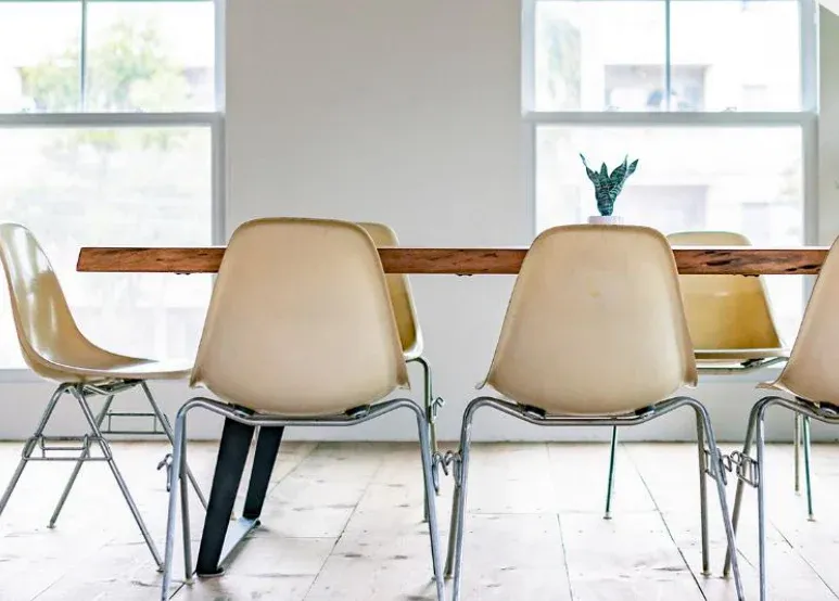 Cafe table with chairs by tall windows. Illustrative image from the developer's catalogue, not the building itself
